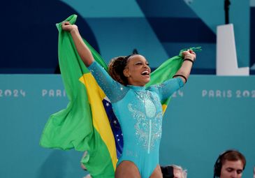 REUTERS/Mike Blake/Proibida reprodução Paris 2024 Olympics - Artistic Gymnastics - Women's Floor Exercise Final - Bercy Arena, Paris, France - August 05, 2024.
Rebeca Andrade of Brazil celebrates with her national flag after winning gold. REUTERS/Mike Blake
